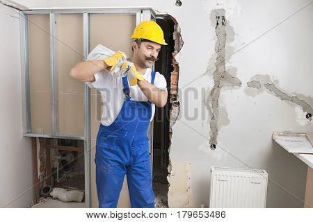 Happy Construction Worker Carrying Poly Bag  