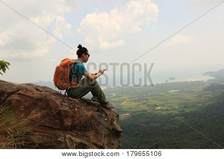 successful woman hiker use cellphone hiking on mountain peak