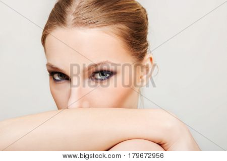 Attractive blonde topless woman with dark eye make up