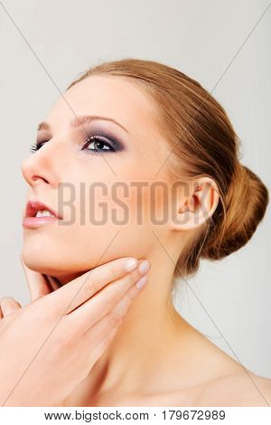 Attractive blonde topless woman with dark eye make up