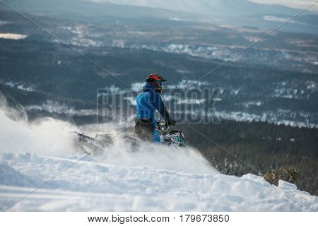 Rider on the snowmobile in the mountains ski resort in Amut Russia.