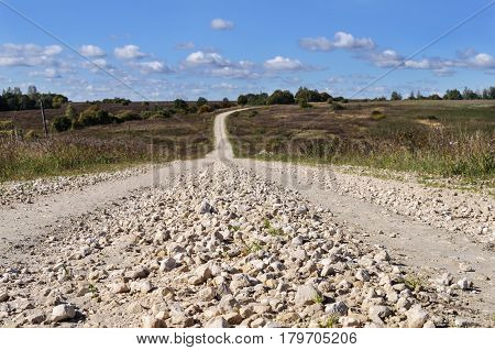 Rural landscape with macadam road through the hills sunny autumn day