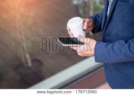 Successful Young Asian Man In Business Casual Attire In Relaxing Outdoor With Cup Of Coffee Looking
