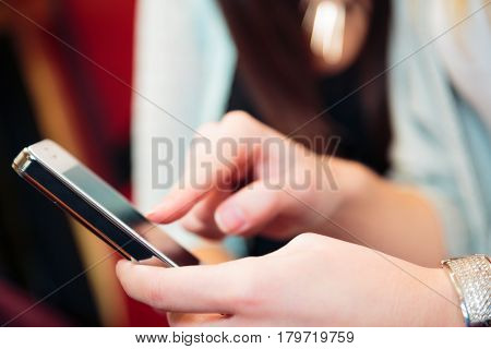 friends having fun at a cafe, texting on their smart phone