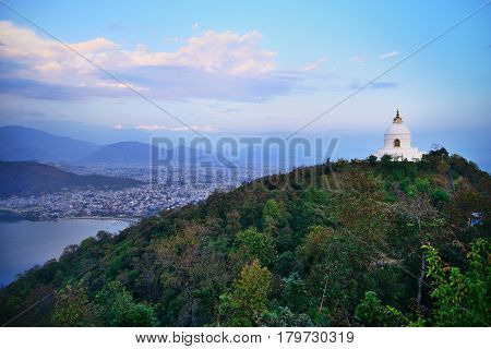 World Peace Pagoda (or Stupa) Pokhara and Phewa lake panorama against sunset sky and Himalaya range with mt. Annapurna and mt. Machapuchare