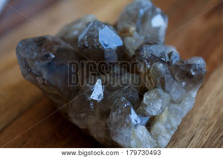 cold, glittering crystal quartz on a wooden table