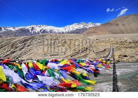 Suspension bridge between Lower Mustang and Upper Mustang with lot of colorful buddhist praying flags Nepal
