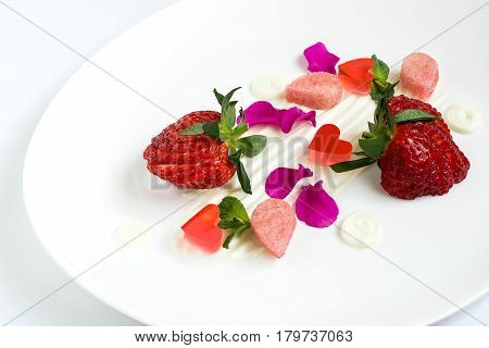Delicious food. Dainty dessert with strawberries cream biscuit cake jelly and edible petals. Easy food for ladies