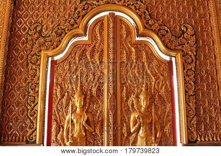 This is a picture of a beaurifully decorated door in Buddha Temple in Thailand.