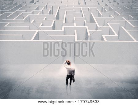 A good looking businessman with briefcase standing in front of white labirynth entrance about to make a decision concept