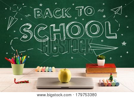 Back to school concepty with writing on blackboard and desk, apple, books, items
