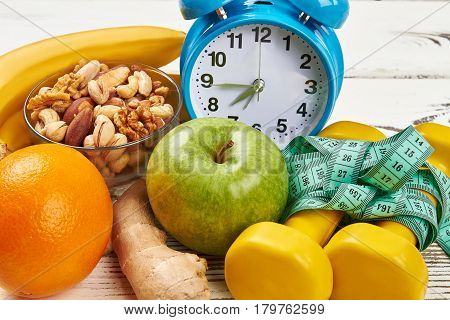 Alarm clock, dumbbells and apple. Eat and sleep rightl.