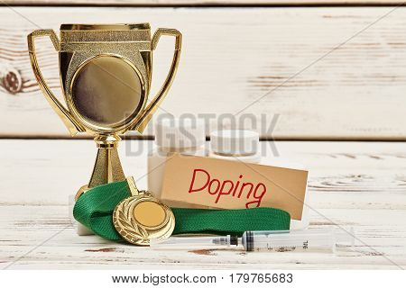 Cup, pills and medal. Reasons for sport disqualification.