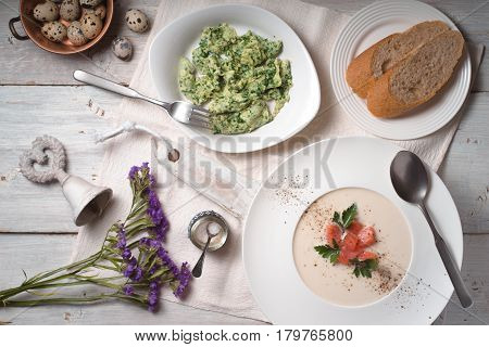 Vichyssoise soup and herb omelet on the white wooden table top view
