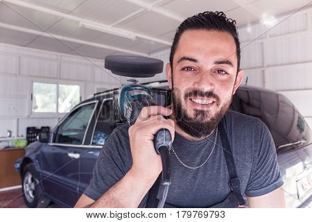 Man holds car polishing tool in the hands and smile