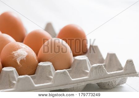 Preparations for Easter. Many light brown eggs in a paperbox.