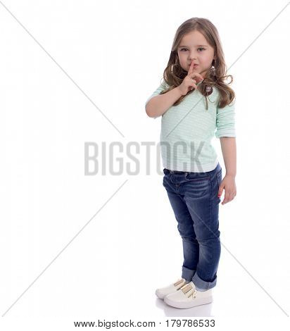Little girl requires silence. Young beautiful kid has put forefinger to lips as sign of silence, isolated on white background