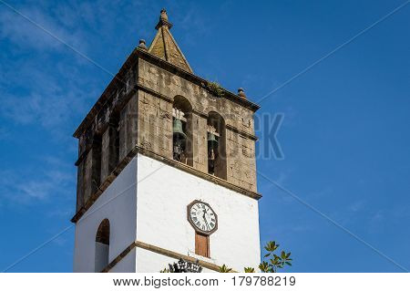 Close view of old tower of Icod de los Vinos with medieval bells and city clock. Icod old town, Tenerife, Spain.