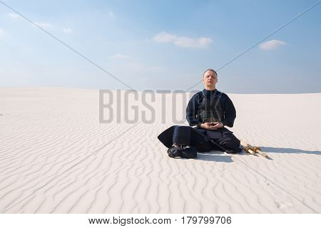 Man In Traditional Armor For Kendo Meditates Before The Practice Of Martial Art