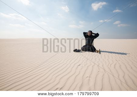 Man Is Sitting In The Middle Of The Desert And Dresses Traditional Armor