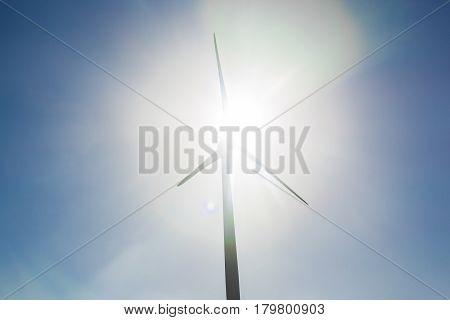 Green renewable energy concept - wind generator turbines in sky.