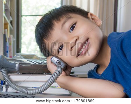Asian kid amking phone call in office