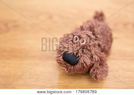 Little soft toy dog on a wooden table, blurry