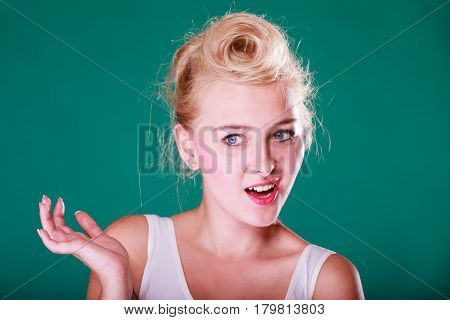 Face expression emotions concept. Young woman with pin up hair being astonishment shocked and disgust. Studio shot on green background