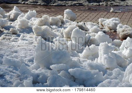 The clods of snow in the street.