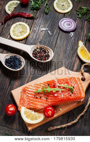 Delicious portion of fresh salmon fillet with aromatic herbs spices and vegetables - healthy food diet or cooking concept.