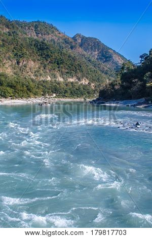 View of River Ganga and amazing blue sky at beautiful colorful day with a colorful jungles on a background houses. Rishikesh. India.