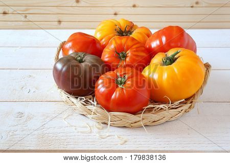 Assortment of Ripe Bullish heart tomatoes in wicker basket