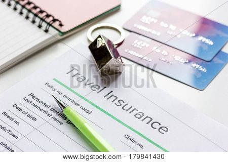 Travel insurance application form with credit cards on white desk background