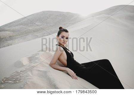 Woman in a black dress in desert