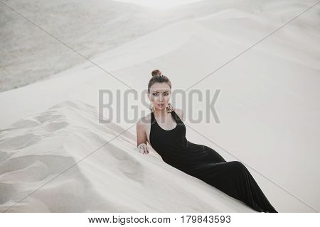 Woman in a black dress in desert