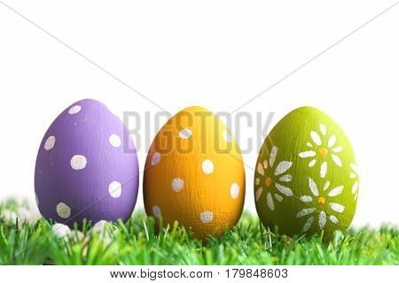 Bunch of easter eggs in pastel colors on grass, isolated on white background