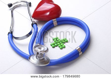 RX prescription, Red heart, asorted pils and a stethoscope on white background.