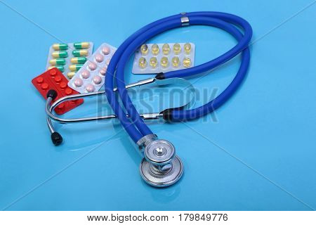 RX prescription, Red heart, asorted pils and a stethoscope on white background.