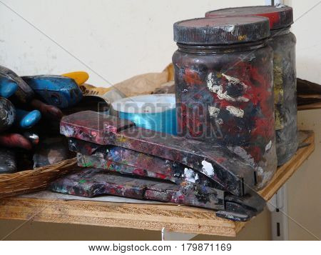 paint crusted jars and stapler in an artist's studio