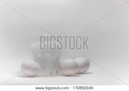 A glass of milk on a white background eggs