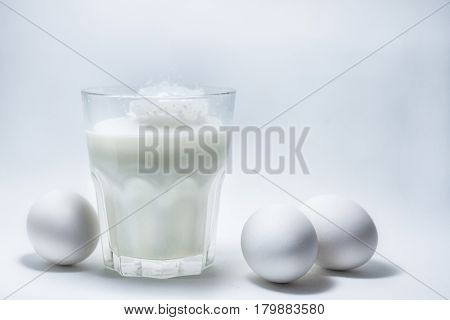 A glass of milk on a white background eggs