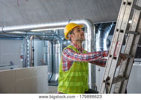 Worker making final touches to HVAC system. HVAC system stands for heating ventilation and air conditioning technology. Team work HVAC indoor environmental comfort concept photo.