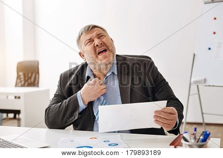 So hot in here. Helpless overwhelmed obese man having a heat stroke while working in the office and trying unbuttoning his shirt