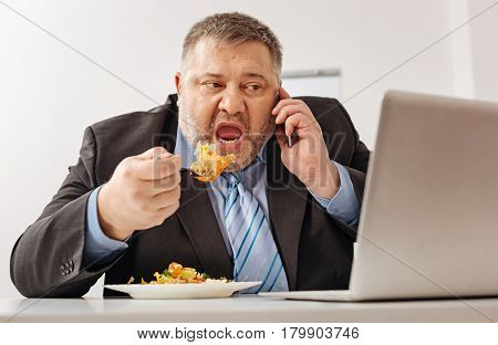 Multitasking on its best. Comical busy hardworking guy stressing out before the deadline having a lot of tasks and not finding time for normal break