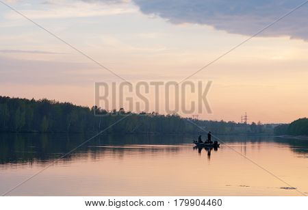 Two fisherman on boat fishing at sunset at Moscow region
