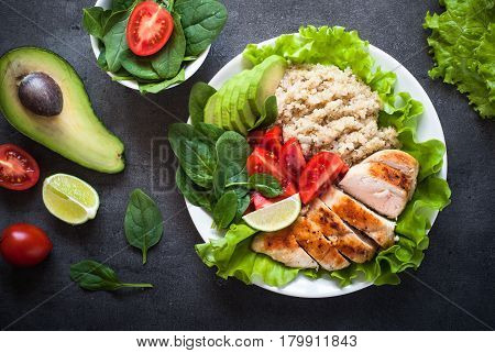Balanced nutrition. Fresh salad from quinoa chicken breast avocado spinach lettuce and tomatoes. Healthy food. Portion plate.