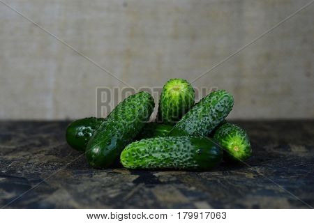 Fresh cucumber on a wooden table and background