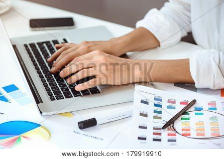 Close up photo of businesswoman's hands  typing on laptop at worplace.