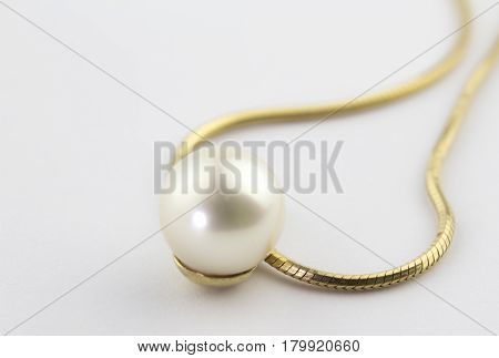 Single peal pendant on gold chain isolated on white background