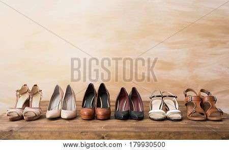Organized woman's shoes on wooden floor background